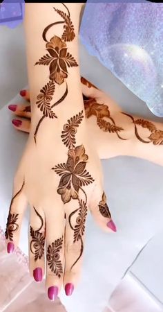 a woman's hand with henna tattoos on it