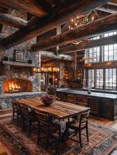 a rustic kitchen with stone fireplace and wooden dining table in front of an open fire place