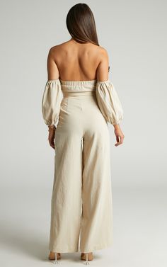 Keep it sweet, classy and a little flirty in the Maja Jumpsuit! This effortlessly stylish one-and-done piece features a sweetheart neckline with a self-tie bust, cut out detail on the front, bardot puff sleeves and high waisted wide leg pants. It's a stunning ensemble that you can wear to parties, long lunches and more. Team it with some fine jewellery, high heels and add a mini top handle bag to complete the look! Product Details  Zip and hook-and-eye fastening on the pants Self-tie fastening a Off-shoulder Jumpsuits And Rompers For Summer Date Night, Fitted Summer Jumpsuits And Rompers With Sweetheart Neckline, Fitted Summer Bottoms With Cut-out Waist, Chic Strapless Backless Jumpsuit, Chic Strapless Jumpsuit For Date Night In Summer, Elegant Strapless Jumpsuit For Beach, Chic Off-shoulder Beach Jumpsuits And Rompers, Flirty Backless Jumpsuits And Rompers For Spring, Chic Off-shoulder Jumpsuits And Rompers For Beach