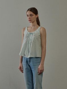 The Ribbon Sleeveless Blouse is a charming and airy top designed for warm weather. This blouse features a playful ribbon detail at the neckline and a loose, flowing fit that offers comfort and style. Its versatile design makes it a perfect match for casual outings or relaxed gatherings. - This Ribbon Sleeveless Blouse features a playful ribbon detail at the neckline, adding a touch of femininity.- The loose, flowing fit ensures comfort and ease of movement, making it ideal for warm weather.- Its versatile design allows it to be paired with various bottoms, from jeans to skirts, for a casual yet stylish look.- The blouse is perfect for casual outings or relaxed gatherings, providing both comfort and style. Breezy Sleeveless Tops For Vacation, Chic Tank Blouse For Daywear, Breezy Sleeveless Top For Day Out, Casual Cami Blouse For Daywear, Breezy Summer Daywear Tops, Chic Cotton Tank Blouse, Casual Tank Top For Spring Daywear, Casual Camisole Blouse For Daywear, Sleeveless Summer Blouse For Daywear