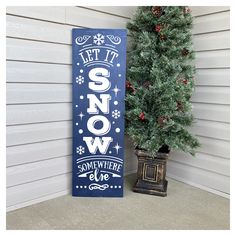 a sign that says let it snow next to a christmas tree on the front porch