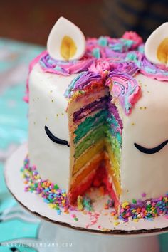 a rainbow unicorn cake has been cut in half