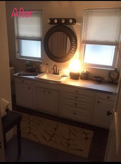 a bathroom sink sitting under a mirror next to a window with light coming through it