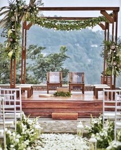 an outdoor wedding setup with chairs and greenery