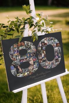 a 50th birthday sign with photos and greenery hanging from it's easel