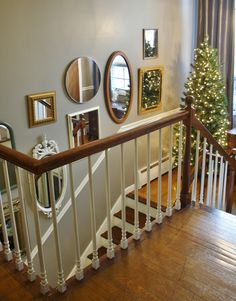 there is a christmas tree in the corner on the bannister next to the stairs