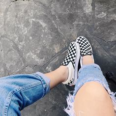 a person wearing black and white checkered shoes