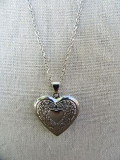 90s silver tone chain with heart locket. Lobster claw closure. Lightweight, costume jewelry. Very cute.  Chain is 20" Locket opens and closes and measures 1-1/8" x 1-1/8" Some light scuffing on underside, otherwise good with no other noted flaws. Vintage Heart Locket Necklace Nickel Free, Metal Heart Necklace With Lobster Clasp, Vintage Silver Heart Pendant Charm Necklaces, Vintage Silver Charm Necklace With Heart Pendant, Vintage Silver Heart Pendant Charm Necklace, Vintage Nickel-free Heart Pendant Charm Necklace, Vintage Nickel-free Charm Necklace For Valentine's Day, Vintage Stainless Steel Locket Necklace, Vintage Heart Necklace With Lobster Clasp