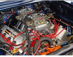 the engine compartment of a car with red hoses