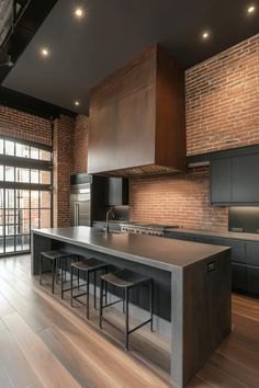 a large kitchen with wooden floors and black cabinets