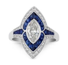 a diamond and blue sapphire ring with diamonds on the sides, set in white gold