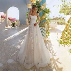 a woman in a white wedding dress posing for the camera