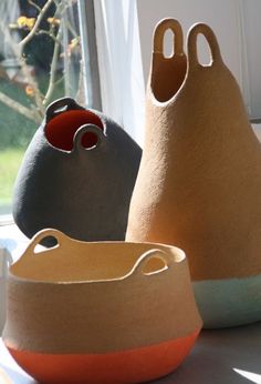 three pots sitting on top of a table next to a window