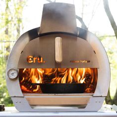 an outdoor pizza oven with flames in it