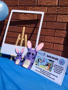 a blue table topped with two stuffed animals next to a sign that says boo baby