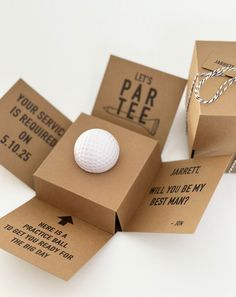 three boxes with golf balls in them sitting on a table next to some string and paper tags