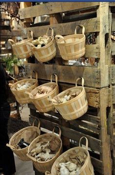 several baskets are hanging on a wooden pallet