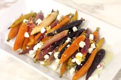 carrots and other vegetables on a plate with feta cheese in the middle, ready to be eaten