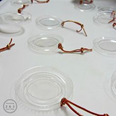 a table topped with lots of clear glass plates and red stringed glasses on top of it