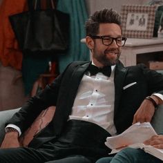 a man in a tuxedo sitting on a couch