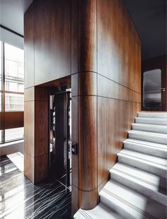 a staircase leading up to an office building with wood paneling on the walls and floor