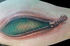 a green zipper tattoo on the shoulder