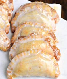 some kind of bread with icing on it sitting on a white plate and the words peach hand pies