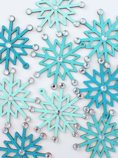 several snowflakes are shown on a white surface with blue and silver glitters