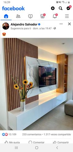 an image of a living room with flowers in the vase on the entertainment center wall