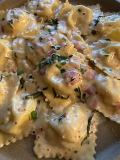 a white plate topped with ravioli covered in cheese