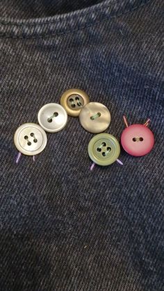 four buttons are sitting on top of a blue shirt