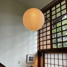 a lamp hanging from the ceiling above a bed in a room with wood paneling