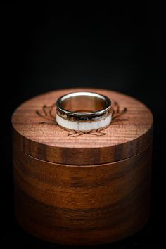 two wedding rings sitting on top of a wooden box