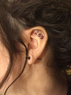 a woman with ear piercings has the word love written on her left side behind her ear