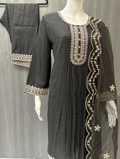 Made from sumptuous Roman Silk, this black party wear silk kurti set is the epitome of elegance and sophistication. The intricate work on the kurti adds a touch of glamour, making it perfect for any special occasion. Available in size 42/46, this premium quality outfit comes with a stunning organza dupatta to complete the look. With its luxurious fabric and exquisite detailing, this kurti set is sure to make a statement at any event. Whether it's a wedding, festival, or other celebration, you'll Chanderi Dabka Palazzo Set For Party, Elegant Raw Silk Sets For Navratri, Elegant Art Silk Sets With Resham Embroidery, Party Traditional Wear In Cotton Silk With Dabka, Party Traditional Wear With Dabka On Cotton Silk, Black Bollywood Style Palazzo Set For Party, Black Bollywood Palazzo Set For Party, Elegant Unstitched Chinon Suit For Festivals, Traditional Palazzo Set With Dabka For Party