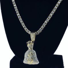 Money Bag pendant one row tennis chain. High quality yellow gold finish over alloy. Dazzling one row neck chain design. Jesus head pendant is 1.25" x .75" inch. Necklace is 24" inches x 4mm wide. Solid jewelry piece weighs 63 grams. Round-cut stone links shine very bright. Stylish & secure box snap clasp closure. This piece looks like a million bucks. 100% FREE SHIPPING in USA. Order now! Gold Rope Chain Jewelry For Streetwear, Gold Rope Chain Jewelry, Luxury Gold Jewelry For Streetwear, Gold Cuban Link Tennis Necklace, Gold Cuban Link Tennis Necklace For Gift, Gold Plated Tennis Necklace - Perfect Gift, Gold Jewelry For Streetwear, Cuban Link Chain Tennis Necklace As Gift, Luxury Cuban Link Tennis Necklace For Gift