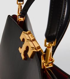 Tory Burch’s timeless Eleanor bags are designed to breathe elegant luxury into your day-to-day. This cross-body satchel version has been fashioned into a more capacious silhouette than its smaller cousins, but still boasts the opulent monogram hardware and removable strap for a fabulous finish. Luxury Logo Top Handle Satchel, Luxury Satchel With Branded Hardware And Top Handle, Designer Gold Top Handle Satchel, Luxury Top Handle Satchel With Logo, Black Top Handle Satchel With Gold-tone Hardware, Cross Body Satchel, Sac Louis Vuitton, Leather Saddle Bags