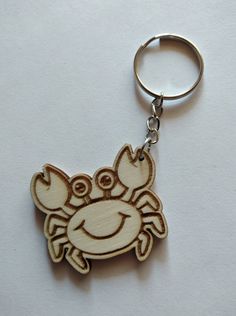 a wooden keychain with an image of a crab on it