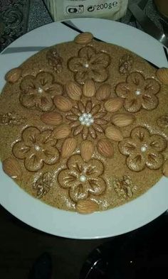 there is a cake that looks like flowers on the plate and has nuts in it