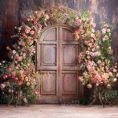 an old wooden door surrounded by pink flowers