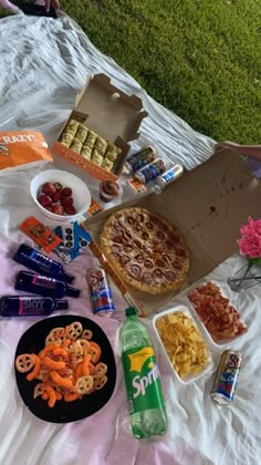 a pizza and other snacks on a blanket