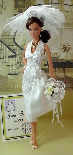 a barbie doll wearing a white dress and veil