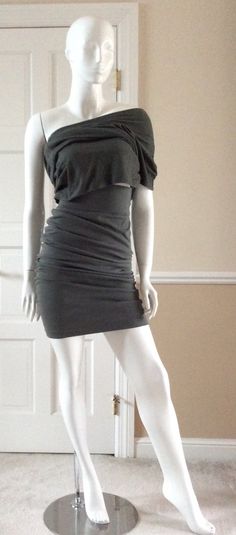 The first four photos show this garment as a top that is ruched at the hips. The next two photos show it ruched as a middy top, or extended as a tunic over the coordinating skirt (shown in a separate listing). This Smokey green tunic top is very versatile. It can be worn as a single sleeve asymmetrical dress or as a short, waist length, or hip length top. It coordinates with the skirt/dress in a separate listing. Size 8USA, but fits a USA 10 as well. Measurements:Bust - 36” Waist - 32”Hips - 34” Fitted One-shoulder Ruched Top, Fitted One Shoulder Ruched Top, Spring One-shoulder Ruched Stretch Dress, Spring One-shoulder Mini Dress With Draped Sleeves, Spring Fitted Draped Asymmetrical Dress, Fitted Draped Asymmetrical Dress For Spring, One-shoulder Stretch Ruched Mini Dress, Fitted One-shoulder Dress With Ruched Sides, Fitted One Shoulder Dress With Ruched Sides