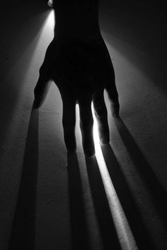 the shadow of a person's hand is cast by a light shining down on them