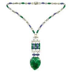 An outstanding Art Deco pendant necklace in highly characteristic colour and design. It is composed of blue and green chalcedony glass rounded baguettes throughout, highlighted with clear cut paste rectangular and square faceted stones. The striking pendant is made of moulded marbled green glass, in a stylised 'heart' design, with moulded patterns to emphasise the decoration. The necklace meets at the back, with a secure push clasp. The necklace is made from silvered metal and is either of Frenc Modern Green Necklace For Formal Occasions, Modern Glass Necklaces For Formal Events, Modern Glass Necklaces For Formal Occasions, Formal Glass Pendant Necklaces, Formal Glass Pendant Necklace, Glass Pendant Necklace For Formal Occasions, Glass Pendant Necklaces For Formal Events, Art Deco Pendant Necklace, Green Chalcedony