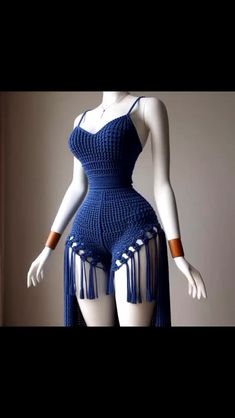 a mannequin wearing a blue crochet dress with tassels on it