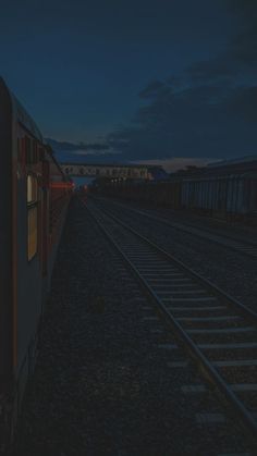 a train traveling down tracks at night time