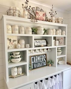 a shelf filled with lots of white dishes and other items on top of it's shelves