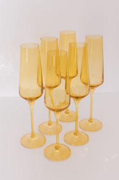 a group of yellow wine glasses sitting next to each other