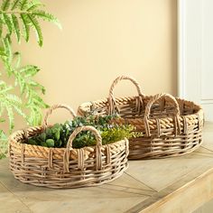 two wicker baskets with plants in them on a table